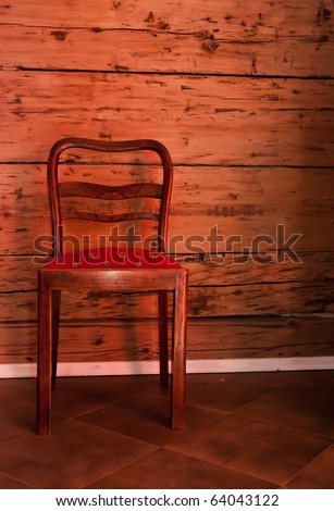 Antique chair on the old wooden wall background. Inside of the old cottage house.