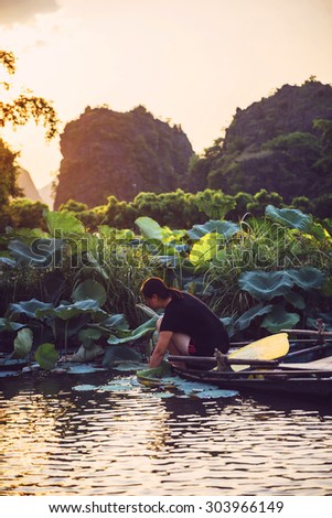 Tamcoc, ninhbinh, Vietnam - May 16, 2015: The unidentified woman sells fruit and water on the boat in ecotourism Tamcoc. This is a famous scenic area in northern Vietnam.