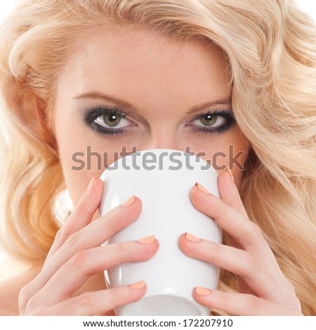 Close up on beautiful young blond hair woman face drinking tea from white mug