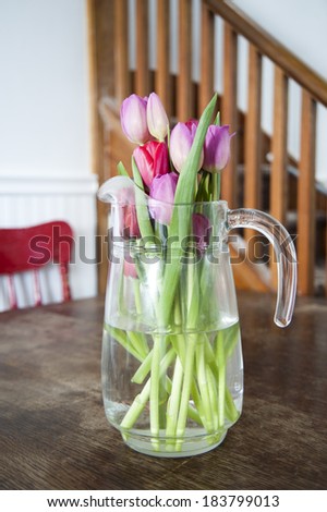 Vase of tulips on table in a country kitchen