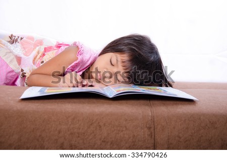 Asian Child Sleep On Bed and a Book
