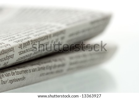 Folded newspaper on shiny reflecting surface - Close-up shot focus on foreground