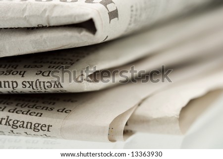 Folded newspaper on shiny reflecting surface - Close-up shot focus on foreground