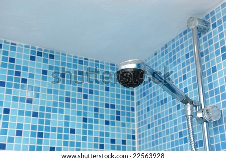 Shower head against blue mosaic tiles