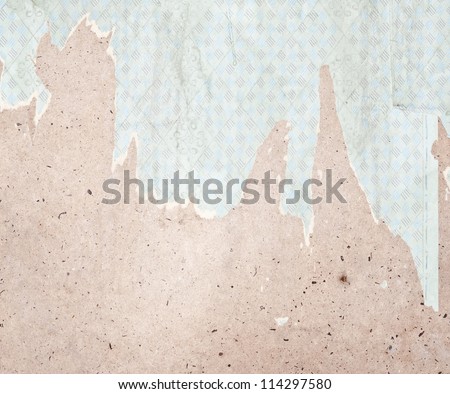 Fragment of old destroyed wall with wallpaper in abandoned house