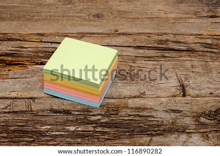 Vibrant block of colorful post it notes on wooden background