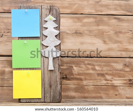 colorful reminder notes attached on a old wooden signboard with paper christmas tree