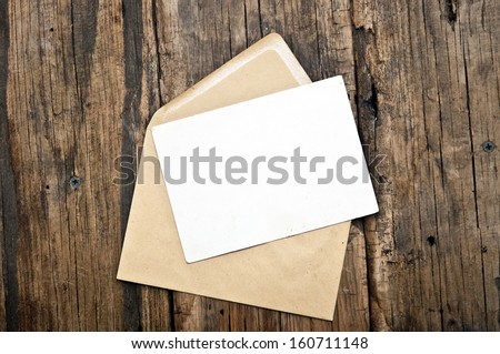 Blank card and envelope on old wooden background