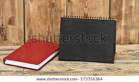 desk calendar with red leather note book on wood table