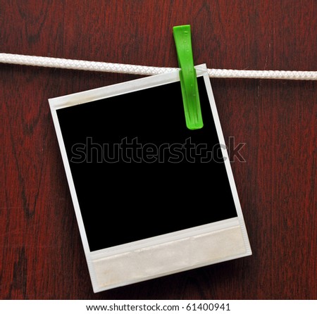 frames attached to a rope on clothespins against a wooden background