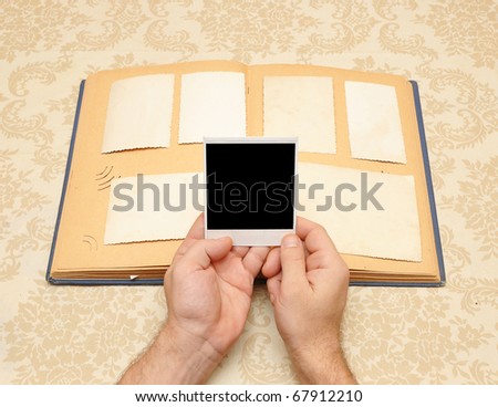 male hands on an old vintage photo album