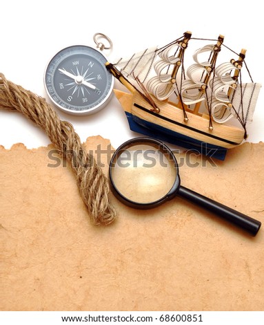 rope, magnifying glass, compass and model classic boat on old paper
