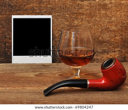 old photo, pipe and glass of cognac on wood background