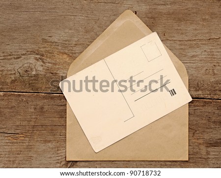 Blank vintage postcard and envelope on old wooden background
