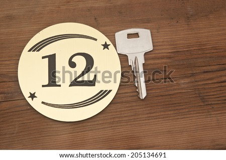 Hotel suite key with room number 12 on wood table
