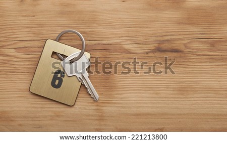 Hotel suite key with room number 6 on wood table