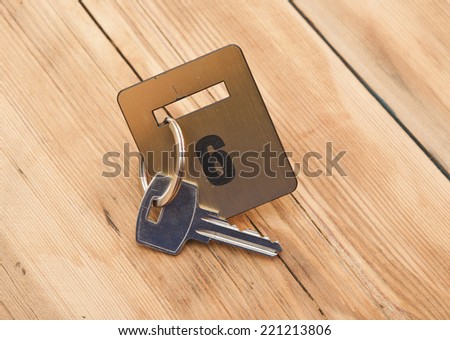 Hotel suite key with room number 6 on wood table