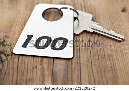 Hotel suite key with room number 100 on wood table