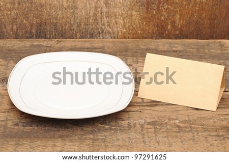 White empty plate with old paper on wood table