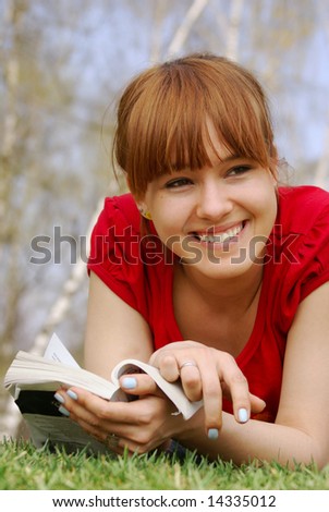 Girl in a park reading funny book