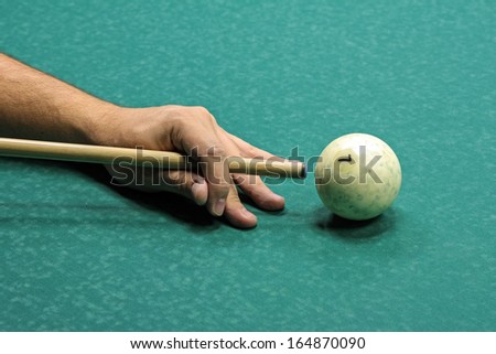 Russian billiard play, hand, ball and cue on the table cloth