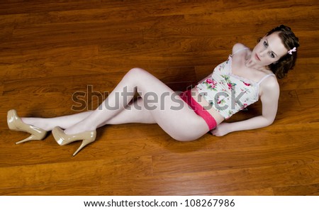 Beautiful woman laying on a wood floor.