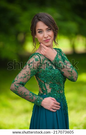 Close portrait of young adult woman in the park, official dress, smiling