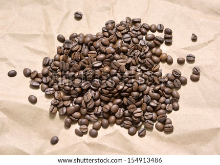 Horizontal composition with coffee grains lying on brown paper