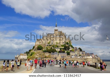 MONT SAINT-MICHEL,FRANCE-AUGUST 12: Crowds of tourists on the dam in front of Saint Michel.The Mont Saint-Michel is an international place of pilgrimage;August 12, 2012 in Mont Saint-Michel, France.