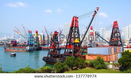 HONG KONG, CHINA - DECEMBER 13: Container ship under cranes at Hong Kong port at  Western Kowloon on December 13, 2012 Hong Kong, China.