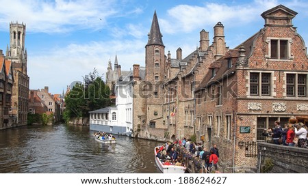 BRUGGE, BELGIUM - AUGUST 07, 2012: Boat with tourists during Canal Boat Tour at Rozenhoedkaai, historic centre of Bruges. The historic city centre is a prominent World Heritage Site of UNESCO.