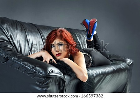 Sexy woman laying on black leather couch
