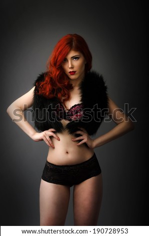 Curvy redhead woman posing in sexy lingerie isolated on gray background