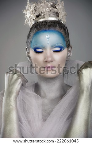 Close up portrait of a woman with creative make up and body painting as Ice Queen