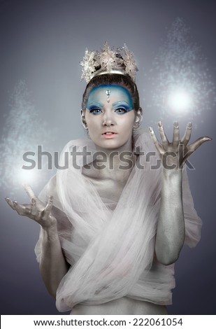 Model with creative make up and body painting posing as Ice Queen or Winter Fairy