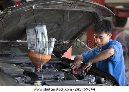 Bangkok, Thailand - January 21 : automobile mechanic examining car suspension of lifted  automobile at at Mitsubishi Motor Service station on January 21, 2015. Bangkok, Thailand.