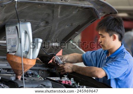 Bangkok, Thailand - January 21 : automobile mechanic examining car suspension of lifted  automobile at at Mitsubishi Motor Service station on January 21, 2015. Bangkok, Thailand.