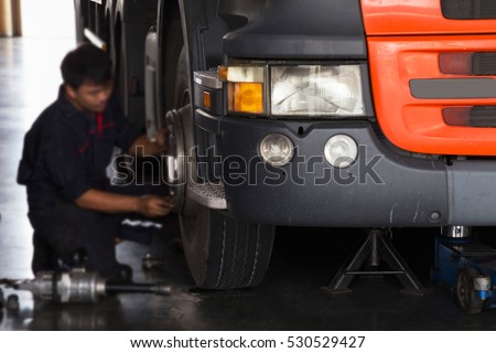 automobile mechanic checking truck in the garage, selective focus