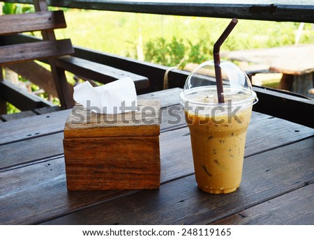 Ice coffee with brown  wooden tissue box