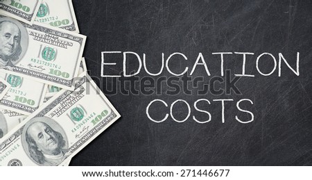 EDUCATION COSTS text on a black chalkboard with a number of one hundred US dollar notes