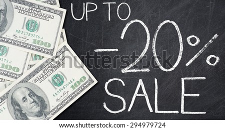 UP TO -20% SALE text written on a blackboard with frame made of 100 US dollars.
