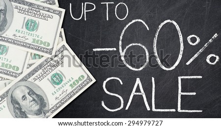 UP TO -60% SALE text written on a blackboard with frame made of 100 US dollars.