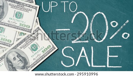 UP TO -20% SALE text written on a green chalkboard with frame made of 100 US dollars.