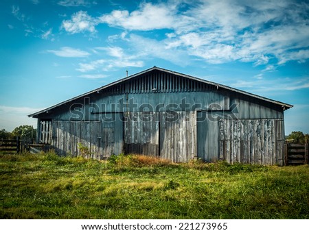 Blue Barn in Summer tucked within a country surrounding in south-central Kentucky sky clouds dusk sunset grass wooden texture rural homestead farm ranch shadow