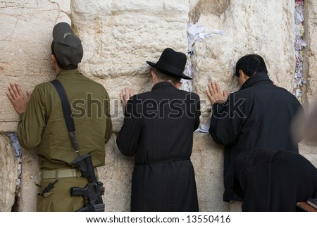 Jew prayers and soldier on Jerusalem Western wall during sabbath.