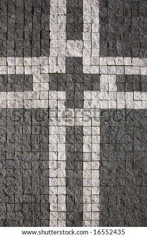 Cube stone structure with cross symbol of Prague pavement. Background texture.