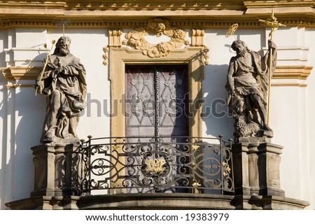 Balcony with statues, metal door and rich decoration on Loreta church in Prague.