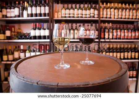 Two glasses on barrel in wine bar-shop.