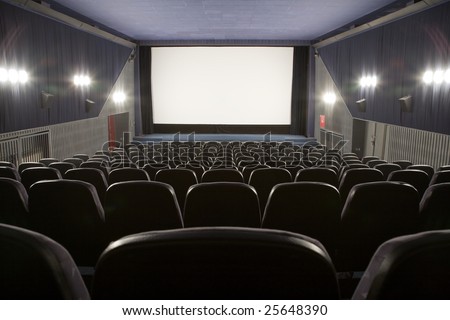 Empty cinema auditorium with line of chairs and stage with silver screen. Ready for adding your own picture.