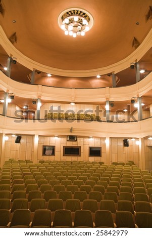 Empty old theater auditorium with balcony and main chandelier.
